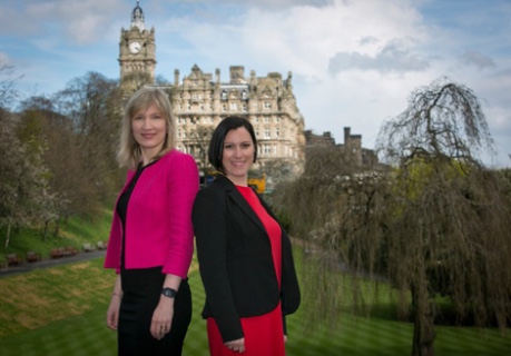 photo of Dr Olga Kozlova, Director, Converge Challenge (Pink jacket) and Dr Claudia Cavalluzzo, Deputy Director, Converge Challenge in Princes Street Gardens with Balmoral Hotel Edinburgh in background