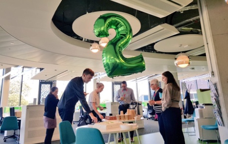 Roslin Innovation Centre celebrating 2 years of business with cake shared with tenants in the open-plan office
